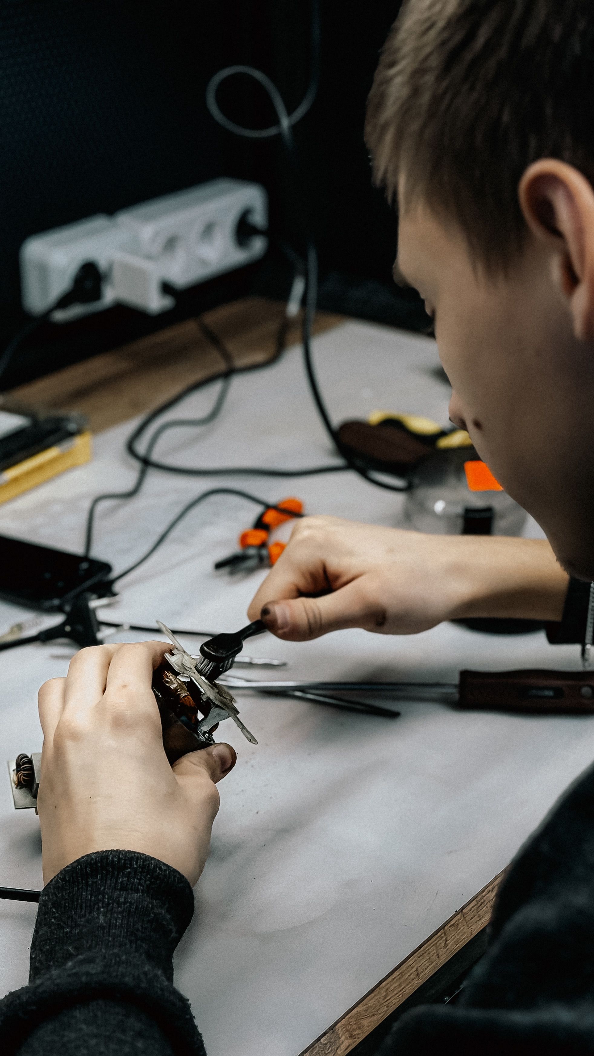 Technician repairing electronics at a workstation